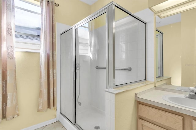 bathroom with tile patterned floors, walk in shower, and vanity