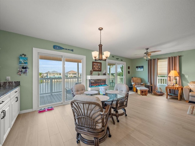 dining area featuring ceiling fan with notable chandelier and plenty of natural light