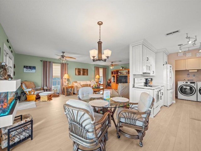 dining area featuring independent washer and dryer, light wood-type flooring, ceiling fan with notable chandelier, and rail lighting