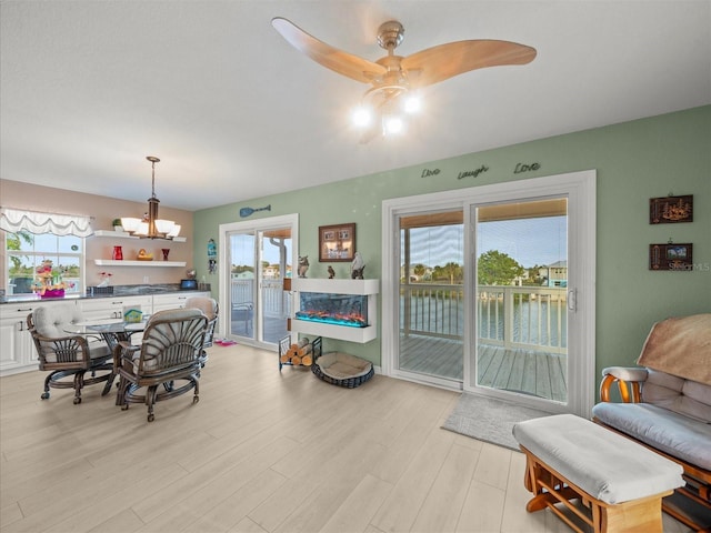 dining space with light hardwood / wood-style flooring and ceiling fan with notable chandelier