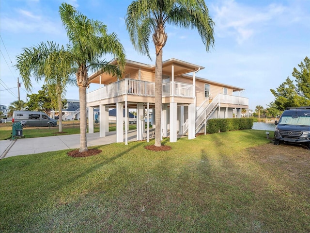 view of front of home with a front yard, a water view, and a carport