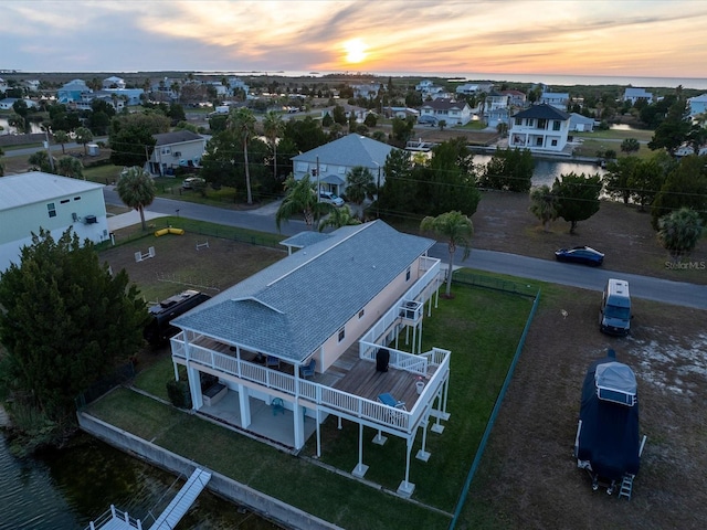 aerial view at dusk featuring a water view