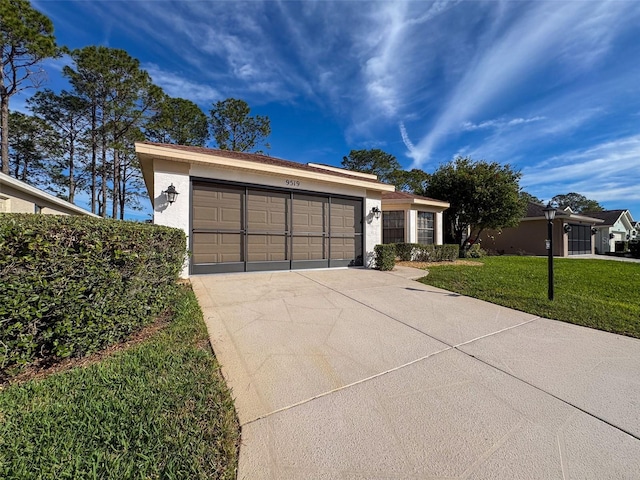 ranch-style house featuring a garage and a front lawn