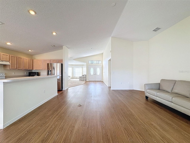 unfurnished living room featuring a textured ceiling, dark hardwood / wood-style floors, and vaulted ceiling