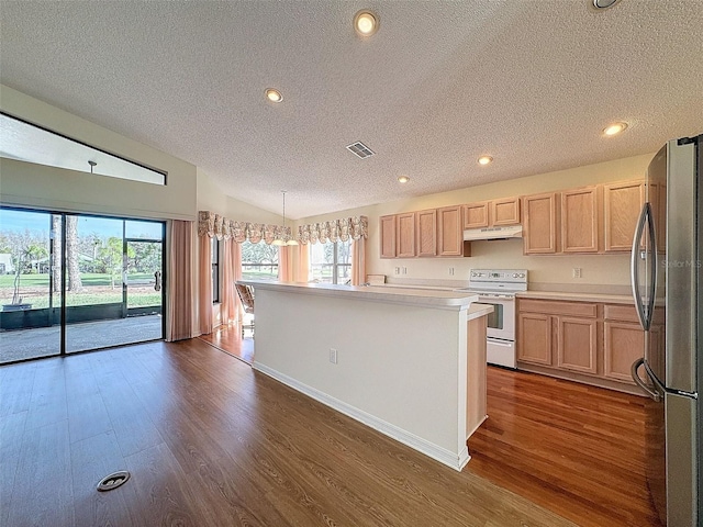 kitchen featuring light brown cabinets, hanging light fixtures, vaulted ceiling, electric range, and stainless steel fridge