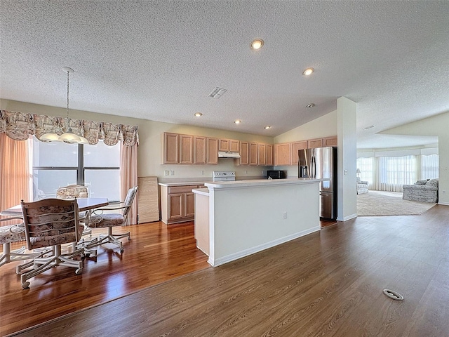 kitchen with pendant lighting, lofted ceiling, dark wood-type flooring, stainless steel fridge, and a textured ceiling