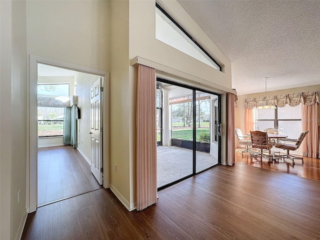 interior space with dark hardwood / wood-style floors, a chandelier, and a textured ceiling