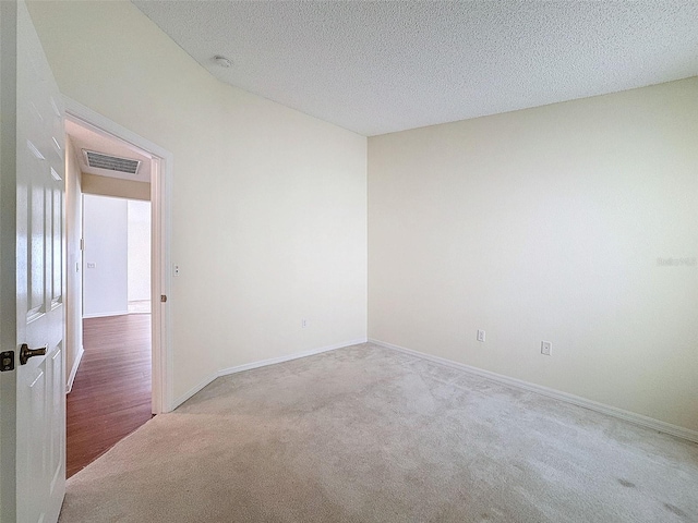 carpeted spare room with a textured ceiling