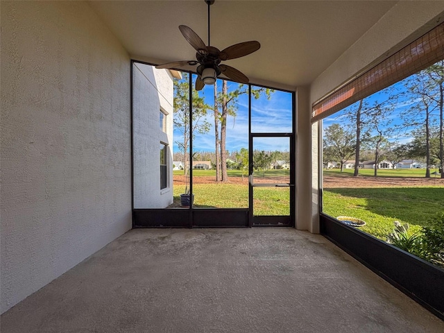 unfurnished sunroom with ceiling fan and plenty of natural light