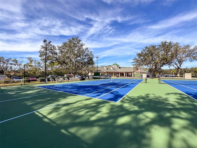 view of tennis court featuring basketball hoop