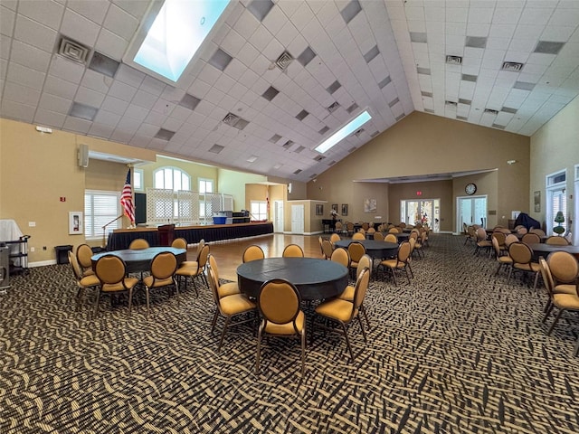 dining space with carpet and a towering ceiling