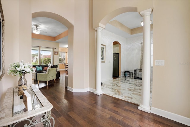 hallway with dark hardwood / wood-style flooring and decorative columns