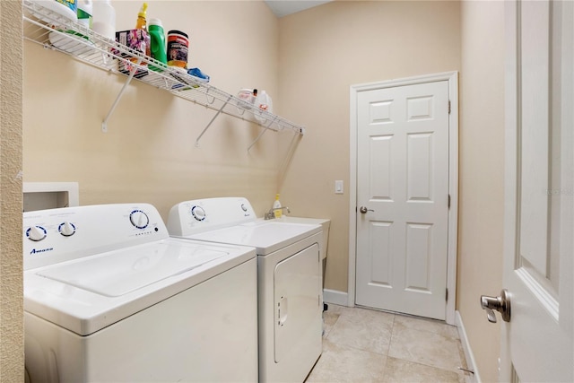 clothes washing area featuring washer and clothes dryer and light tile patterned floors