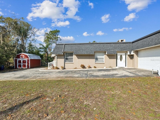 ranch-style house featuring a shed, a front lawn, and a garage