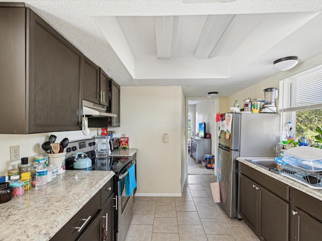 kitchen with dark brown cabinets, a raised ceiling, light tile patterned floors, and stainless steel appliances