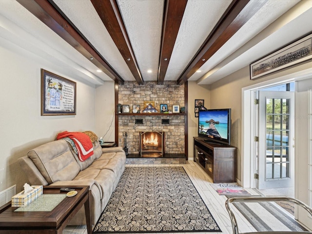 living room with beam ceiling, light wood-type flooring, and a stone fireplace