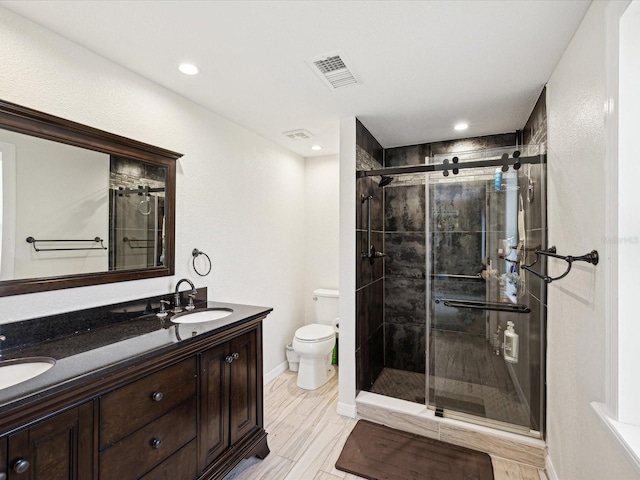 bathroom featuring vanity, toilet, and an enclosed shower