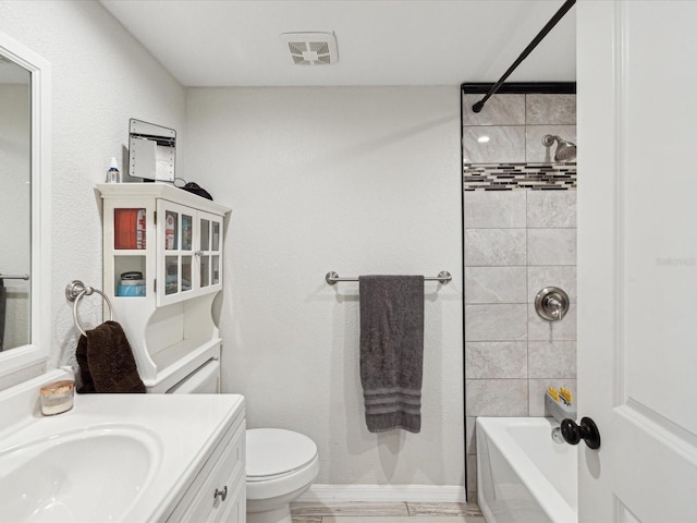 full bathroom with vanity, toilet, and tiled shower / bath combo