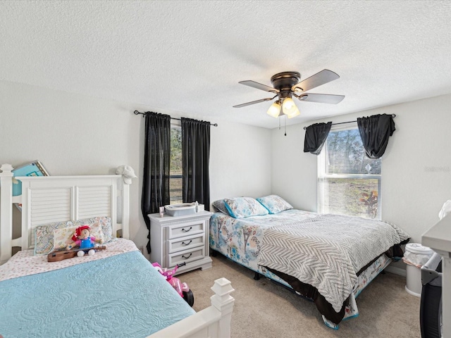 carpeted bedroom with a textured ceiling and ceiling fan