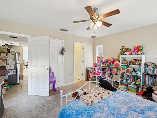 bedroom featuring carpet, visible vents, ceiling fan, and freestanding refrigerator