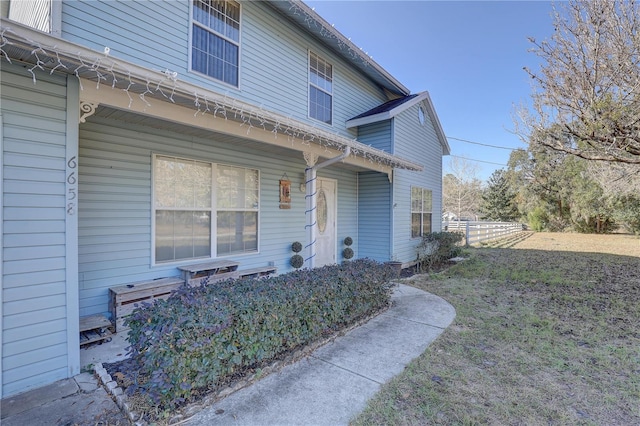 view of exterior entry featuring a yard