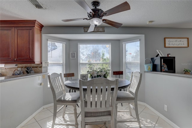 tiled dining room featuring a wealth of natural light, ceiling fan, and a textured ceiling