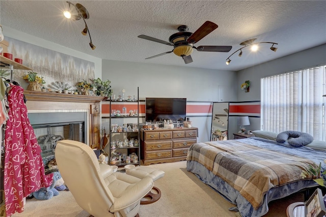 bedroom with ceiling fan, carpet floors, and a textured ceiling