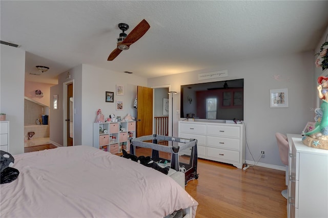 bedroom featuring a textured ceiling, light hardwood / wood-style floors, and ceiling fan