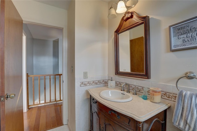 bathroom with vanity and tile walls