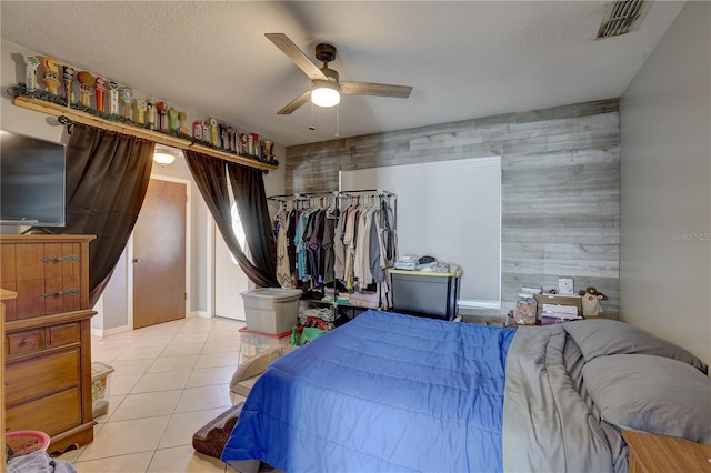 tiled bedroom featuring a textured ceiling and ceiling fan