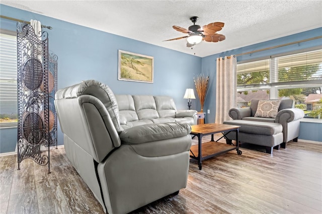 living room featuring hardwood / wood-style floors, a textured ceiling, and ceiling fan