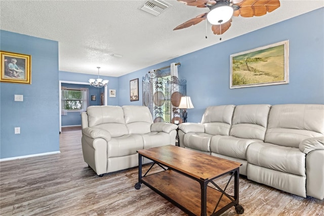 living room featuring hardwood / wood-style floors, a notable chandelier, and a textured ceiling