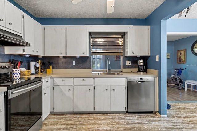 kitchen featuring a textured ceiling, stainless steel appliances, sink, light hardwood / wood-style floors, and white cabinetry