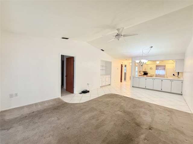 unfurnished living room featuring light carpet, ceiling fan with notable chandelier, and lofted ceiling