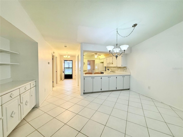 kitchen featuring white cabinetry, white refrigerator, pendant lighting, decorative backsplash, and light tile patterned floors