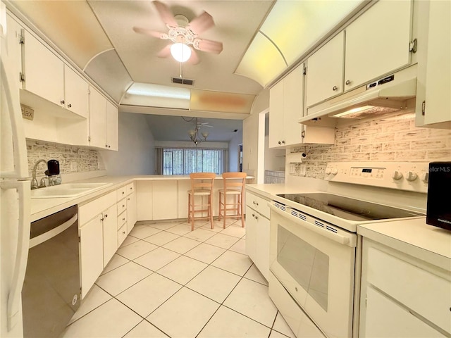 kitchen with pendant lighting, dishwasher, backsplash, white electric stove, and white cabinetry