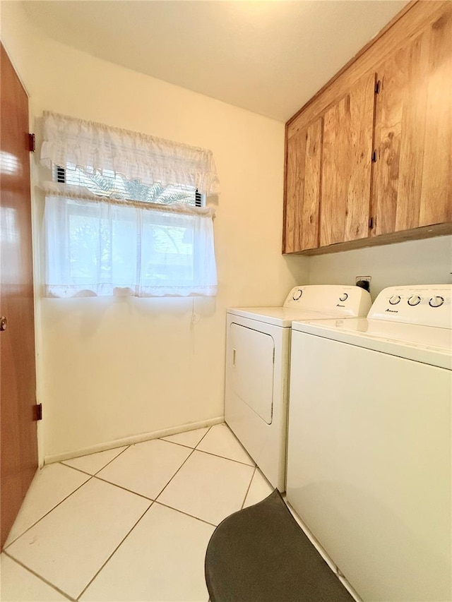 laundry room featuring light tile patterned flooring, cabinets, and independent washer and dryer