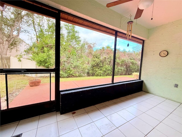 unfurnished sunroom featuring ceiling fan