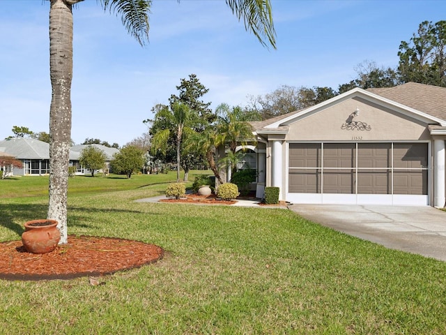 view of front of house with driveway, an attached garage, a front yard, and stucco siding