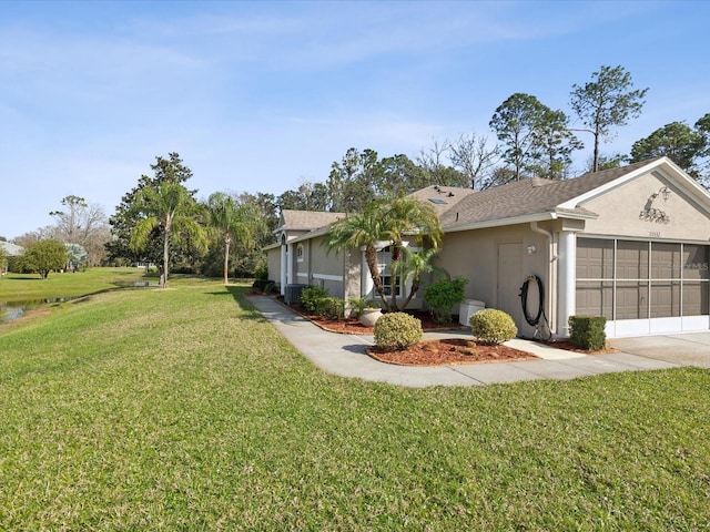 view of front facade featuring a garage, driveway, stucco siding, central AC, and a front yard