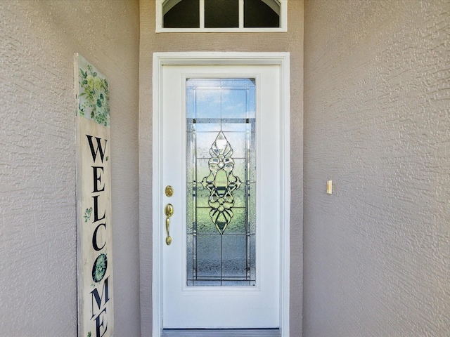 entrance to property with stucco siding