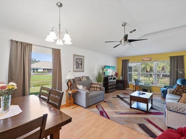 living room featuring a healthy amount of sunlight, light wood-style floors, visible vents, and lofted ceiling