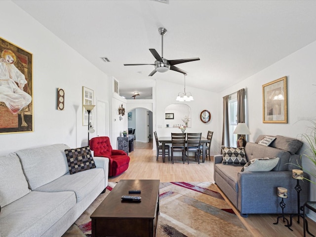 living room with arched walkways, lofted ceiling, visible vents, a ceiling fan, and wood finished floors