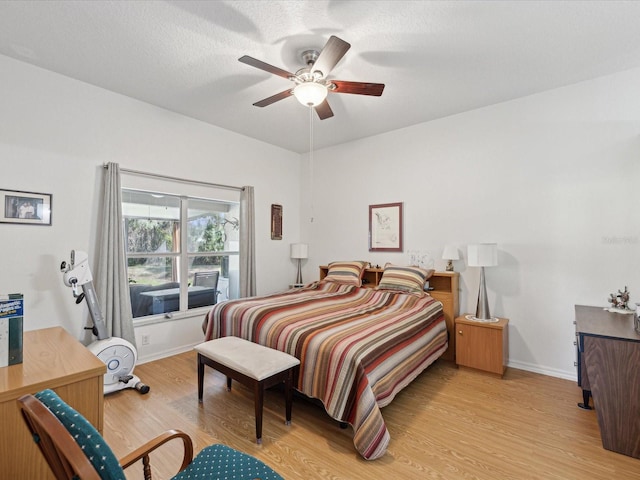 bedroom with baseboards, ceiling fan, a textured ceiling, and light wood finished floors