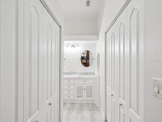 corridor with visible vents and a sink