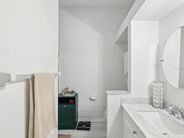 half bathroom featuring baseboards, vanity, and toilet