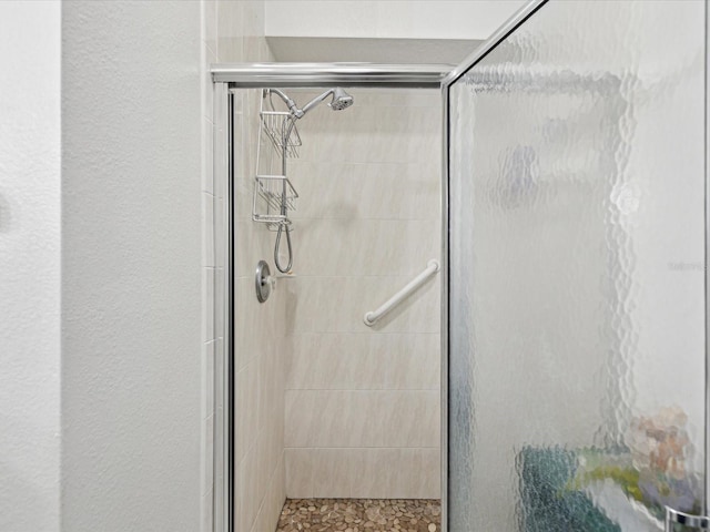 bathroom featuring a stall shower and a textured wall