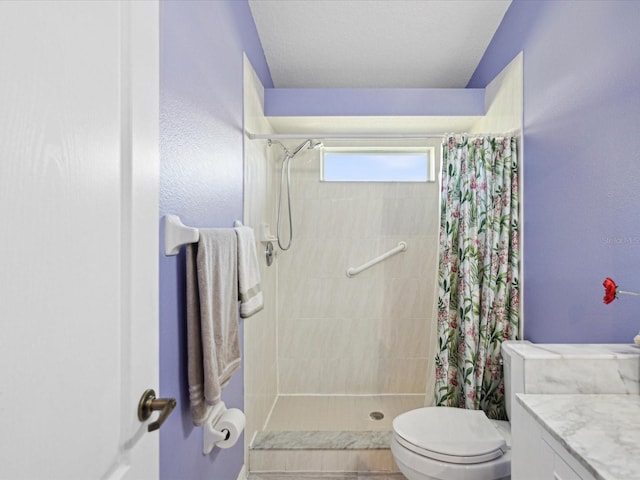 bathroom featuring toilet, a stall shower, and vanity