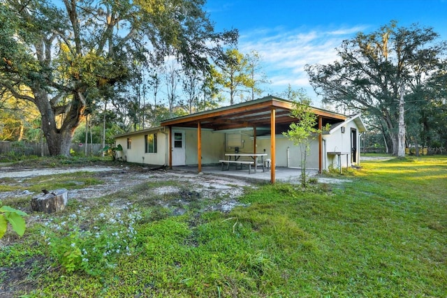 rear view of house with a lawn and a patio area