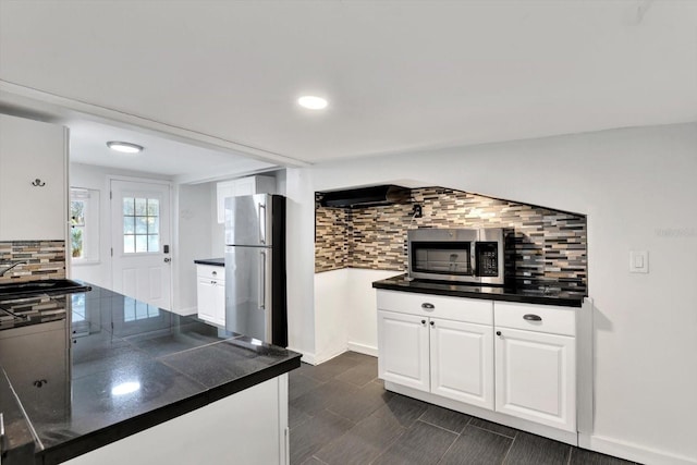 kitchen featuring backsplash, stainless steel appliances, and white cabinetry